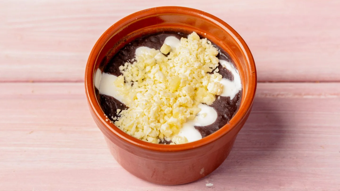 Frijoles topped with crema and cheese