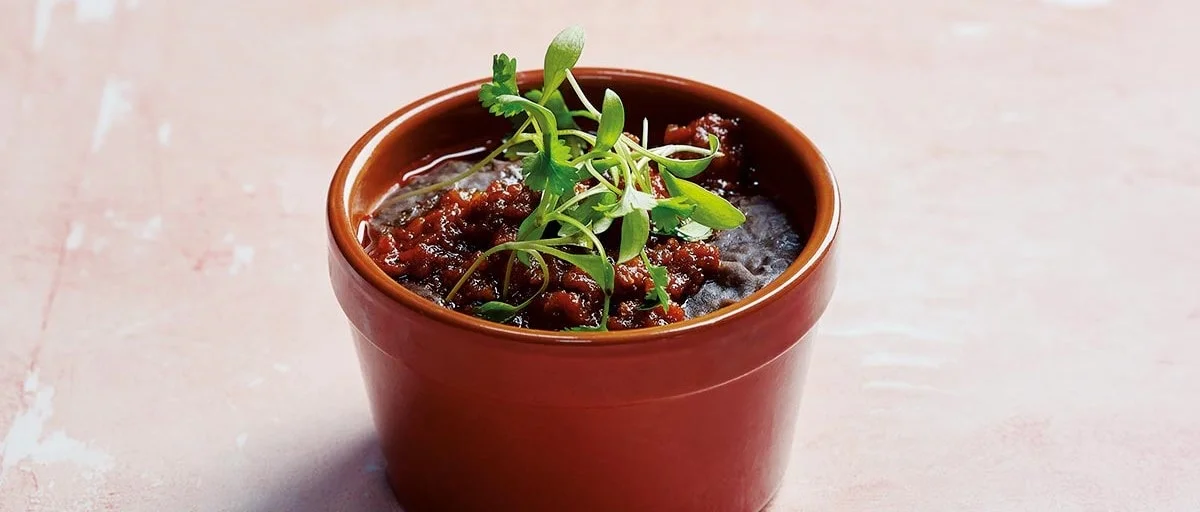 Frijoles topped with chorizo and fresh herbs