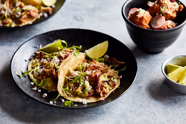 A plate of tacos and side of corn fritters