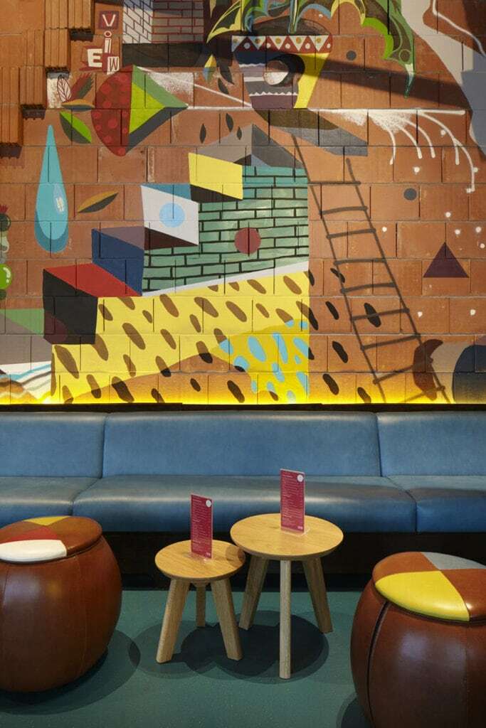 A cosy corner of Wahaca Cardiff with vibrant wall art