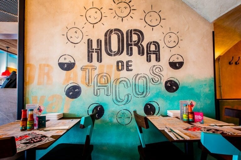 Mural painting saying 'Hora de tacos' on the wall at our Mexican restaurant in Brighton