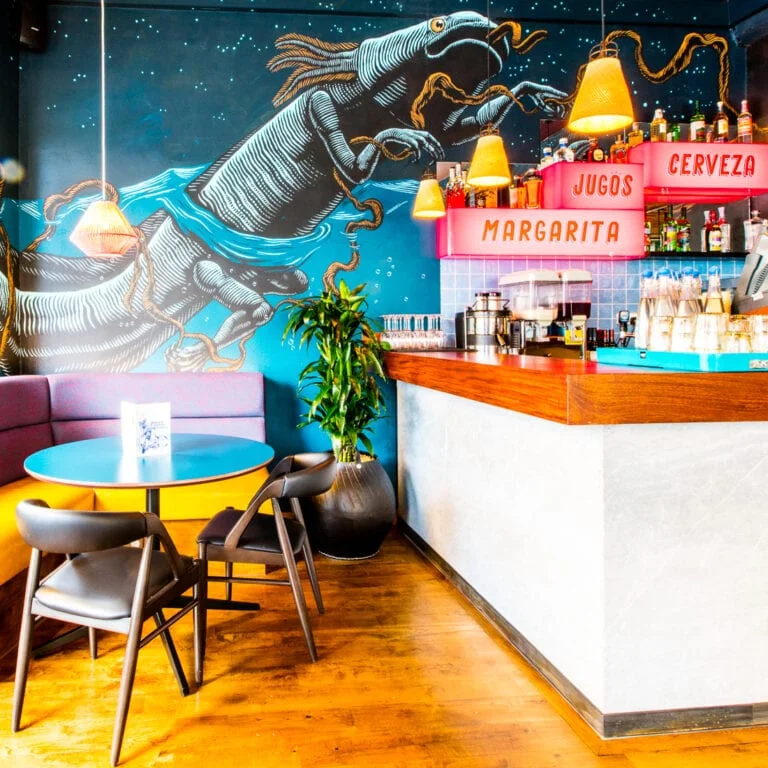 Bold wall art and colourful bar area in Wahaca Brighton