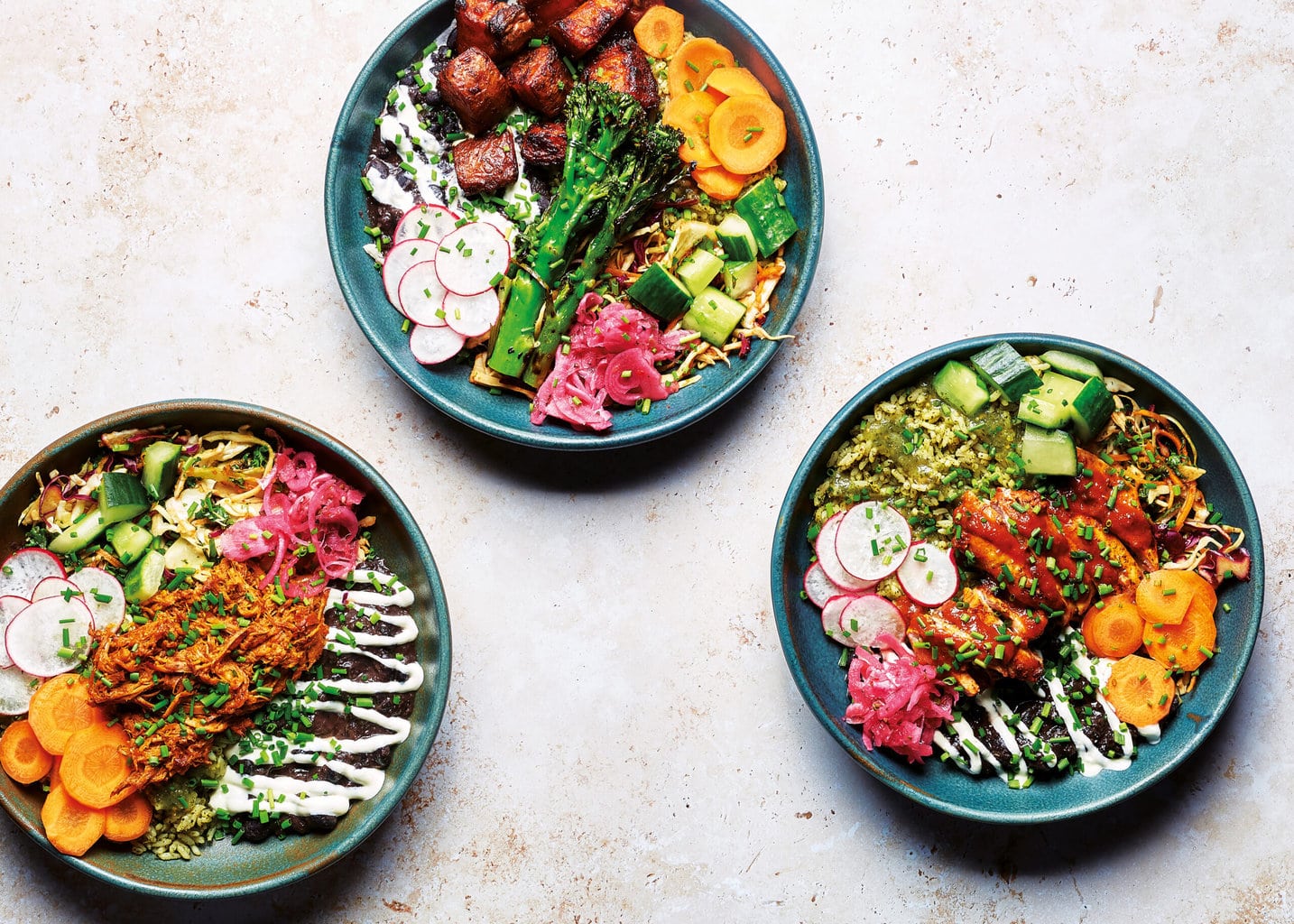 Our three rainbow bowls, packed with fresh vibrant ingredients and topped with broccoli and sweet potato, chicken or pork pibil