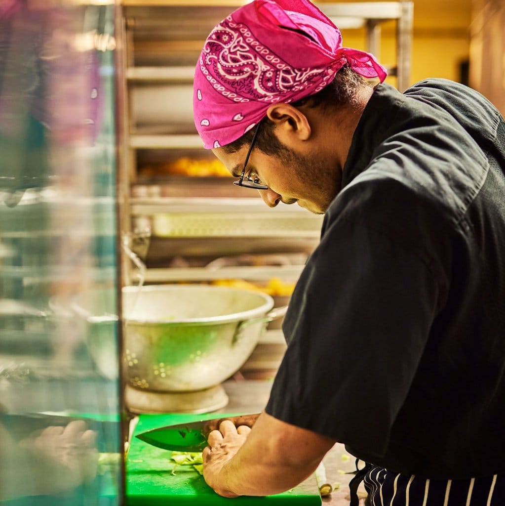 A Wahaca kitchen assistant prepping fresh ingredients