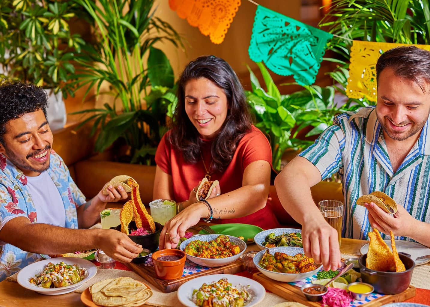 A group filling tortillas with an array of christmas dishes to build their own tacos