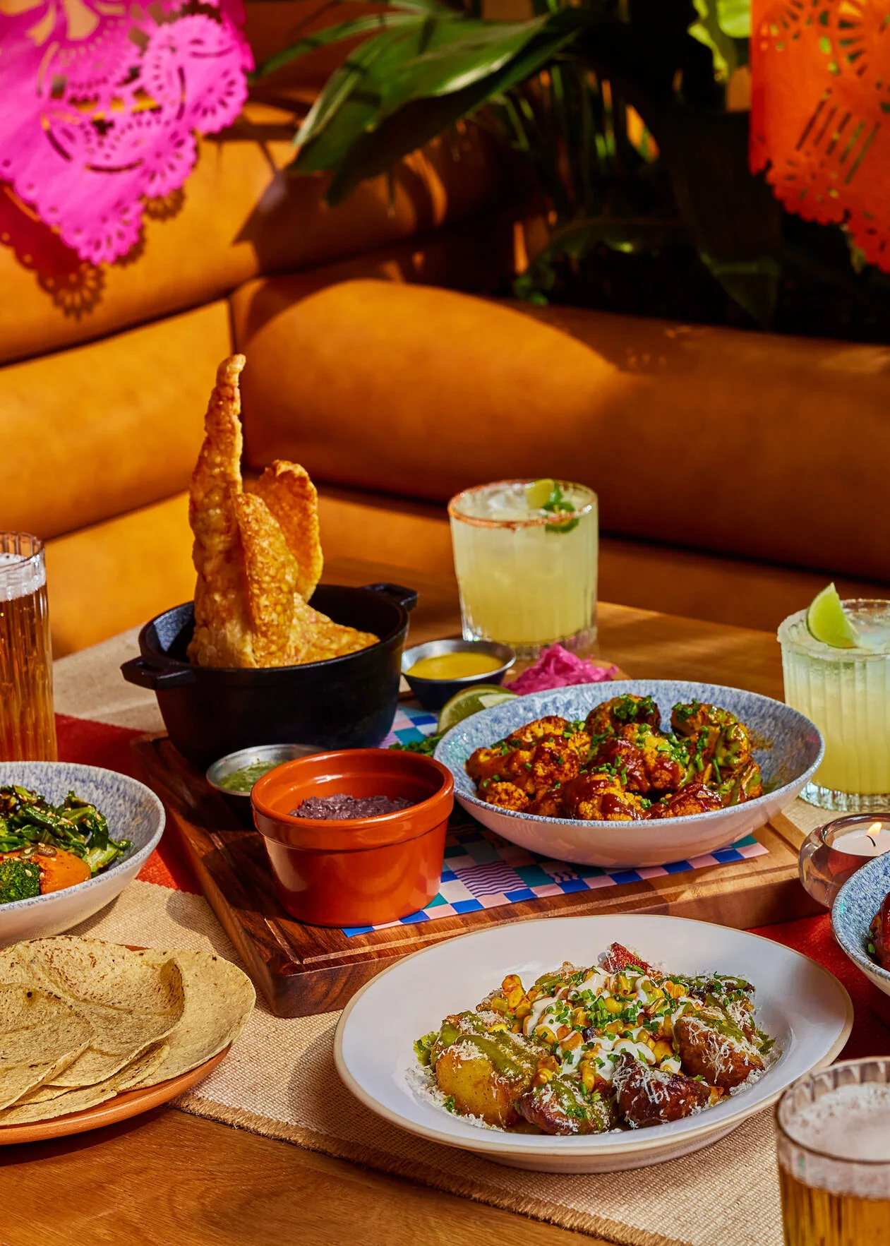 Our festive feast main dishes filling a table, accompanied by beers and margaritas