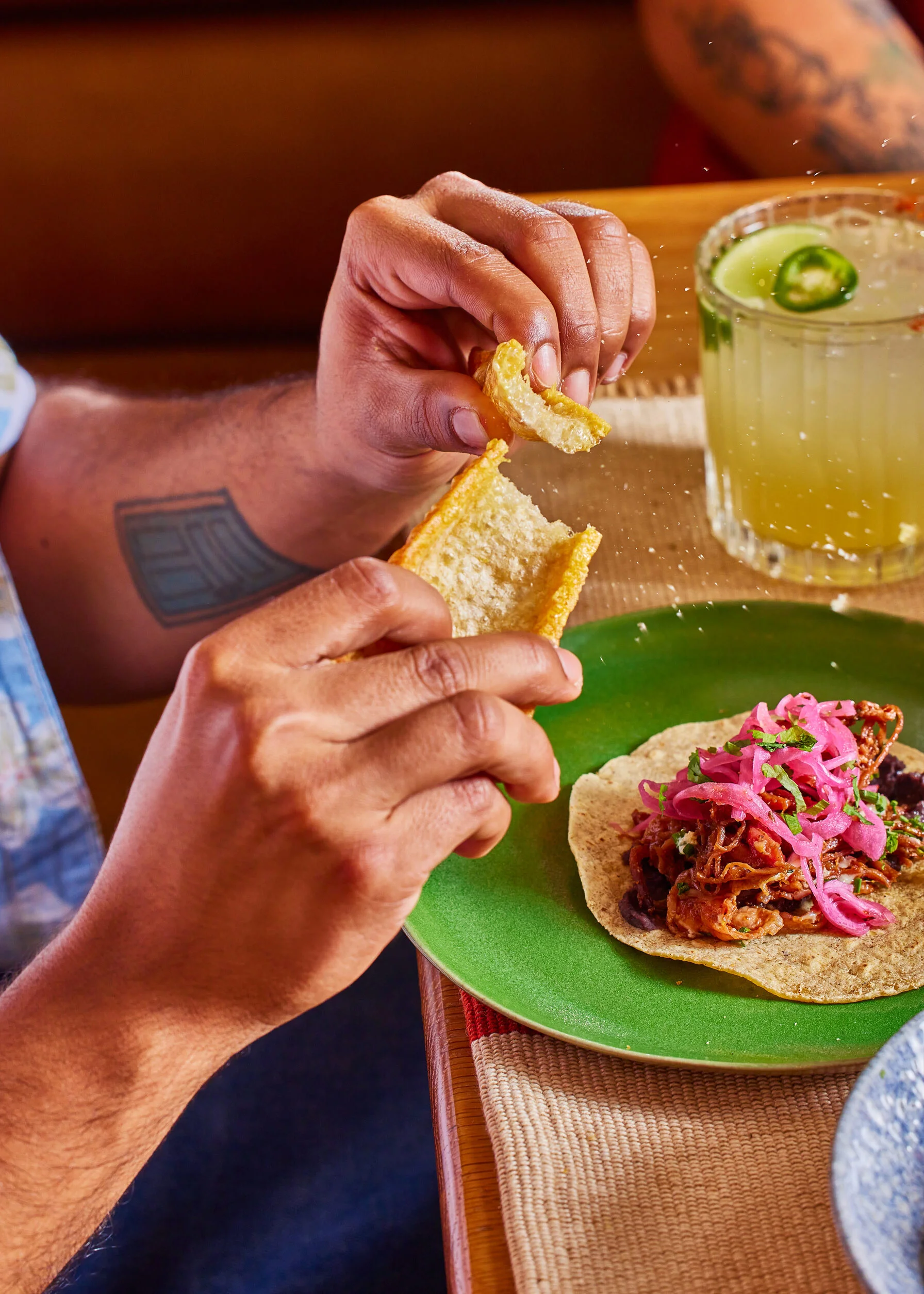 Our crispy crackling being broken in two over a ham hock filled taco