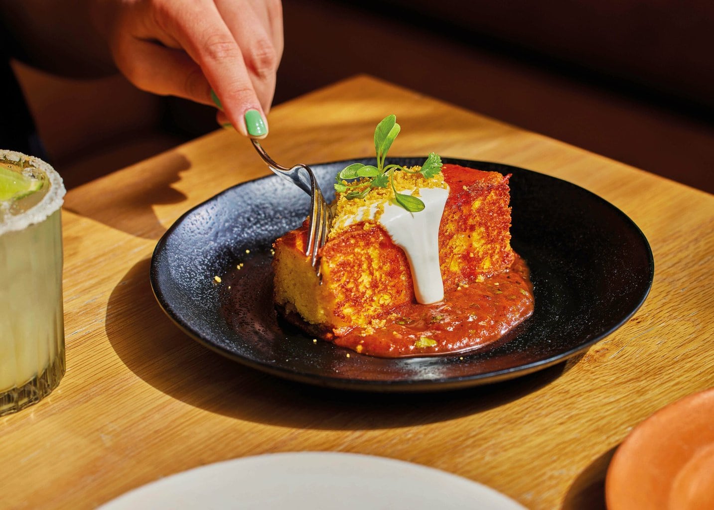 Toasted corn bread with whipped goats curd and a chipotle agave glaze, topped with micro herbs
