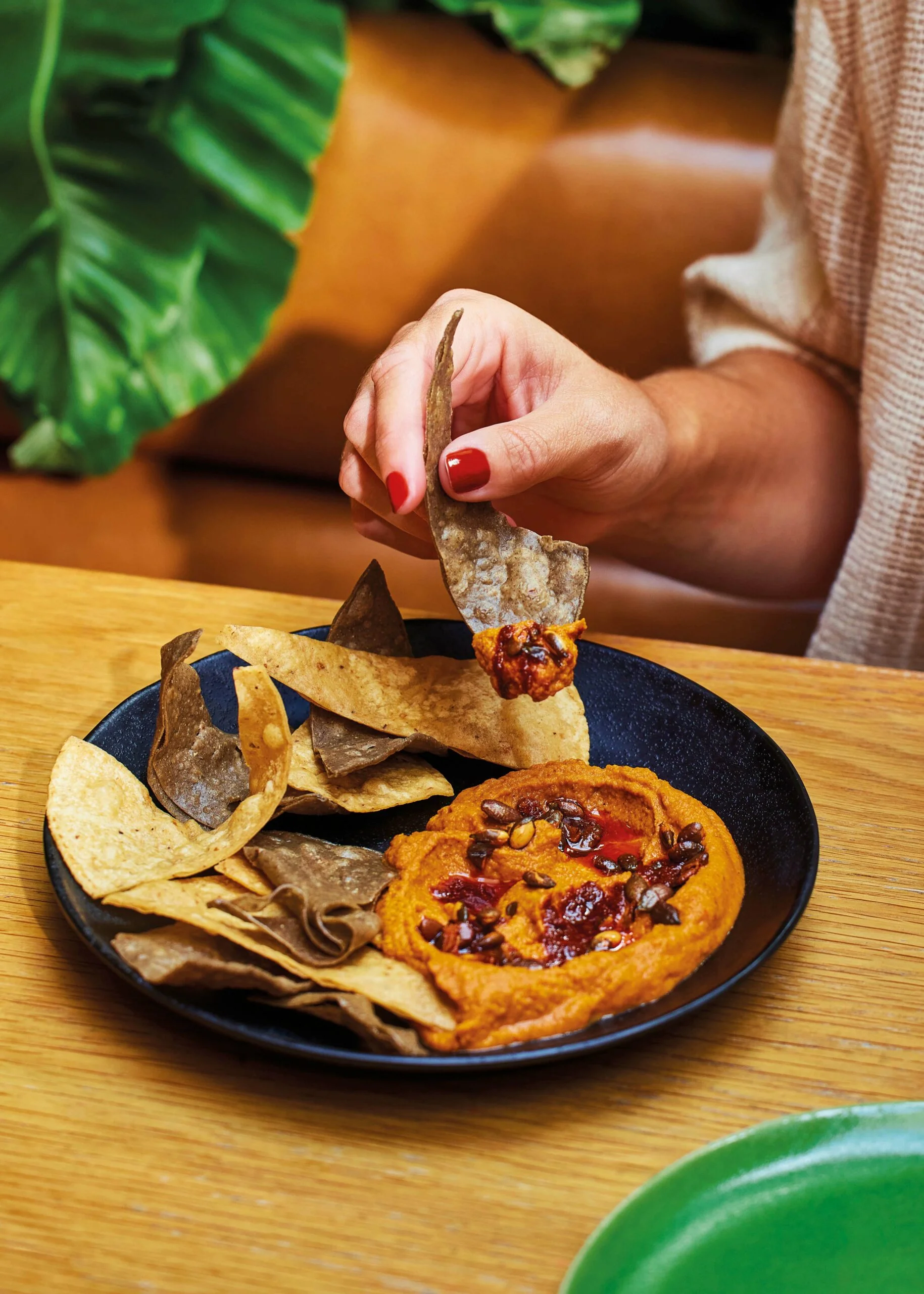 Sonoran hummus with a tortilla chip dipping in