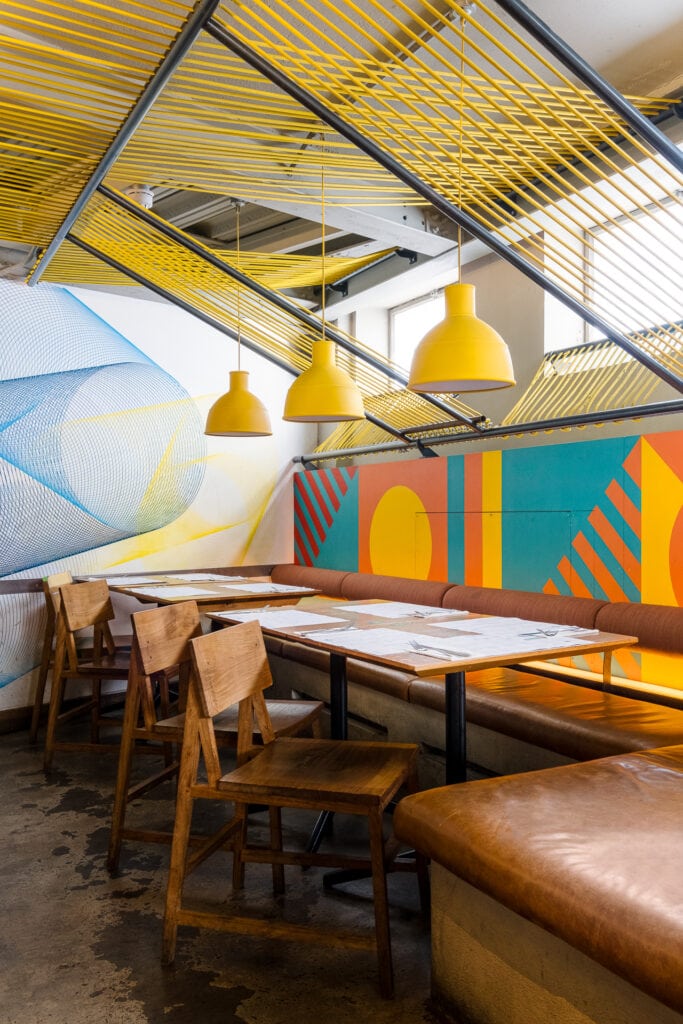 restaurant seating and mural art at wahaca waterloo