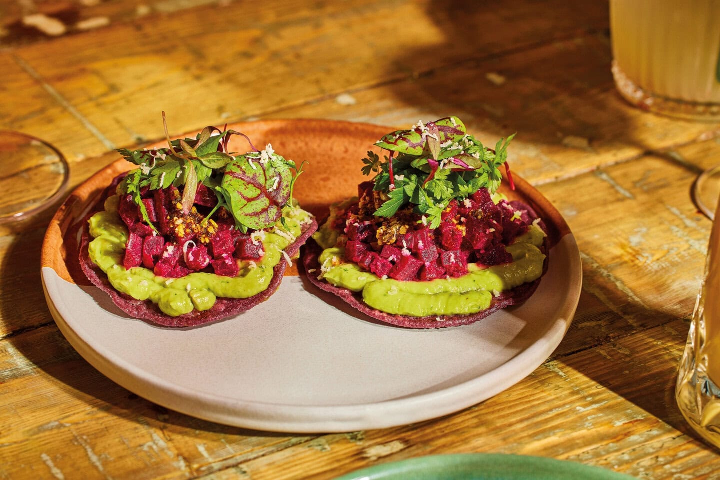 A vegan Mexican dish of two beetroot tostadas, with avocado cream, salsa macha and horseradish