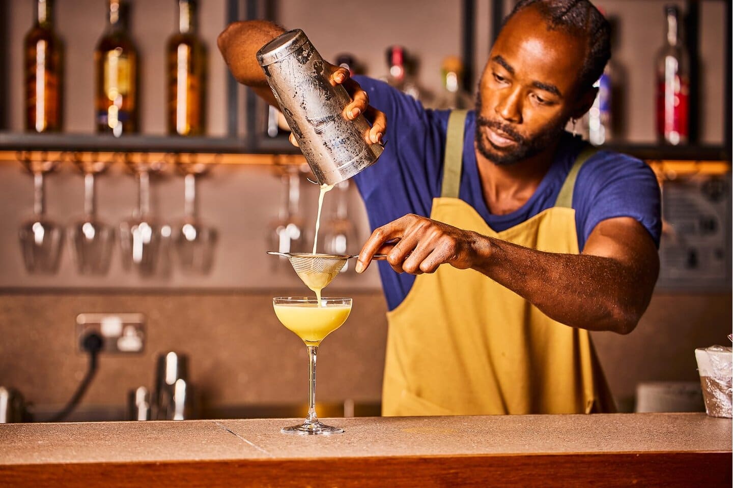 Bar team pouring a freshly shaken cocktail